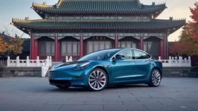 Une Tesla Model 3 devant un temple chinois traditionnel.